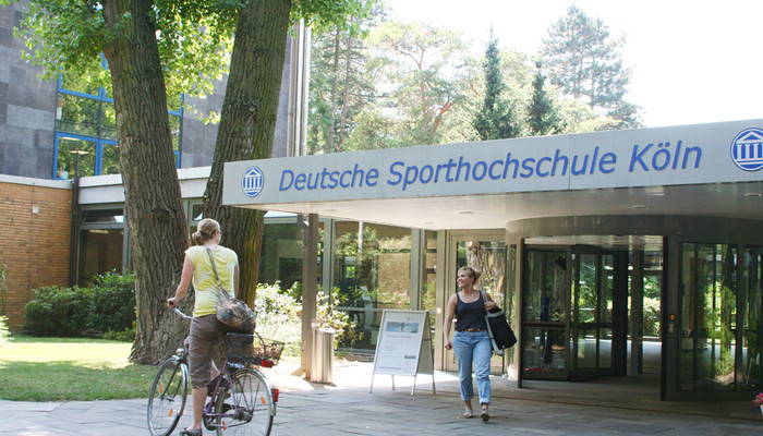 Der Haupteingang der Deutschen Sporthochschule Köln Bild Studierender vor dem Haupteingang der DSHS
