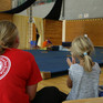 Betreuerin und Kind von hinten in einer Turnhalle